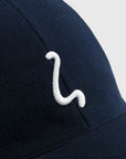Navy blue cap with a white logo on a light gray background