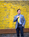 Lesovs Black and Yellow Eclipse Tie in front of yellow wall