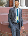 Lesovs Gray Curves Silk Tie on man in front of bricks