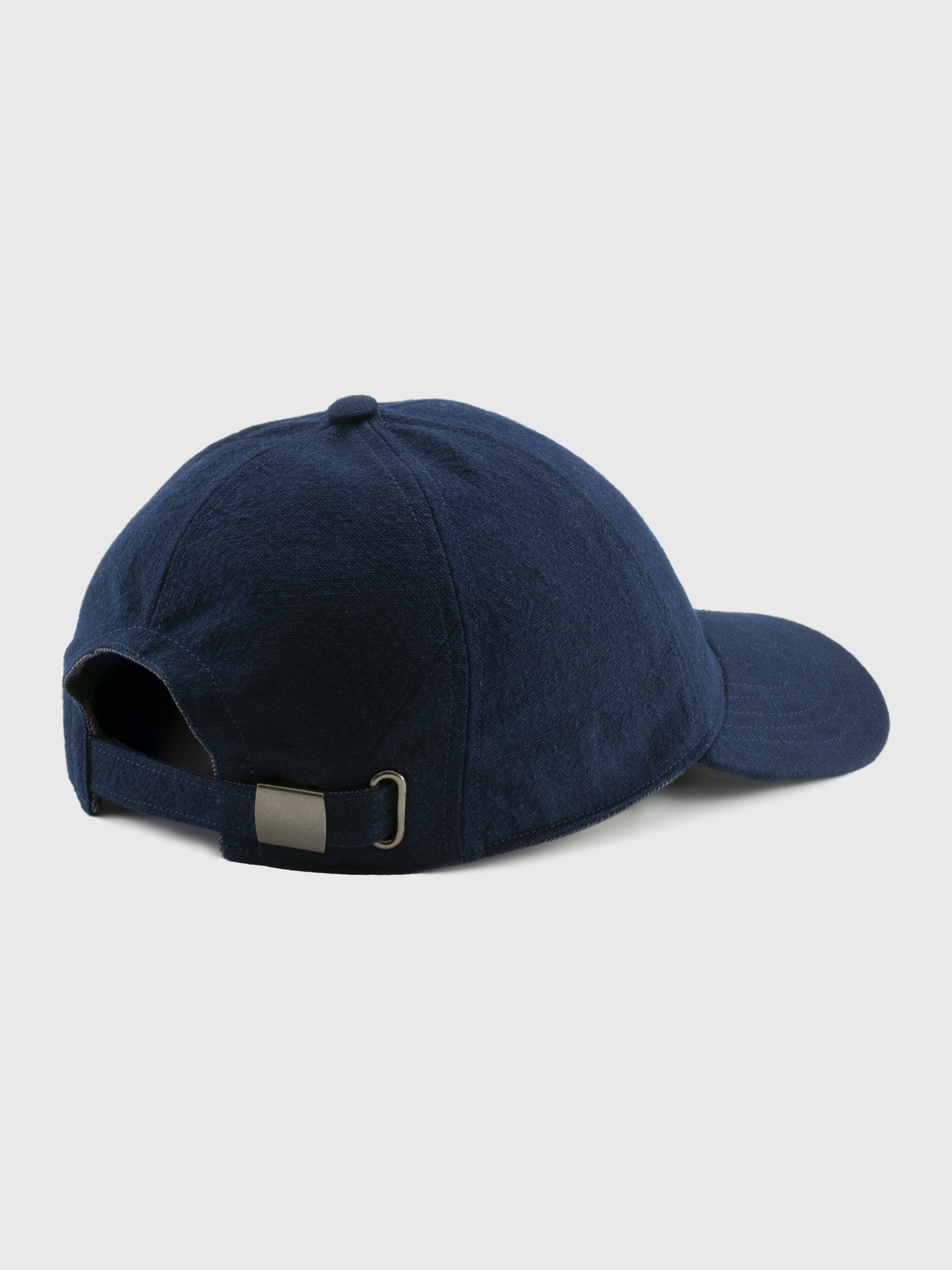 Navy blue cap with a metallic buckle on a light gray background