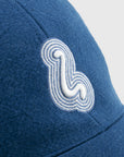 Blue cap with a white embroidered logo on a light gray background