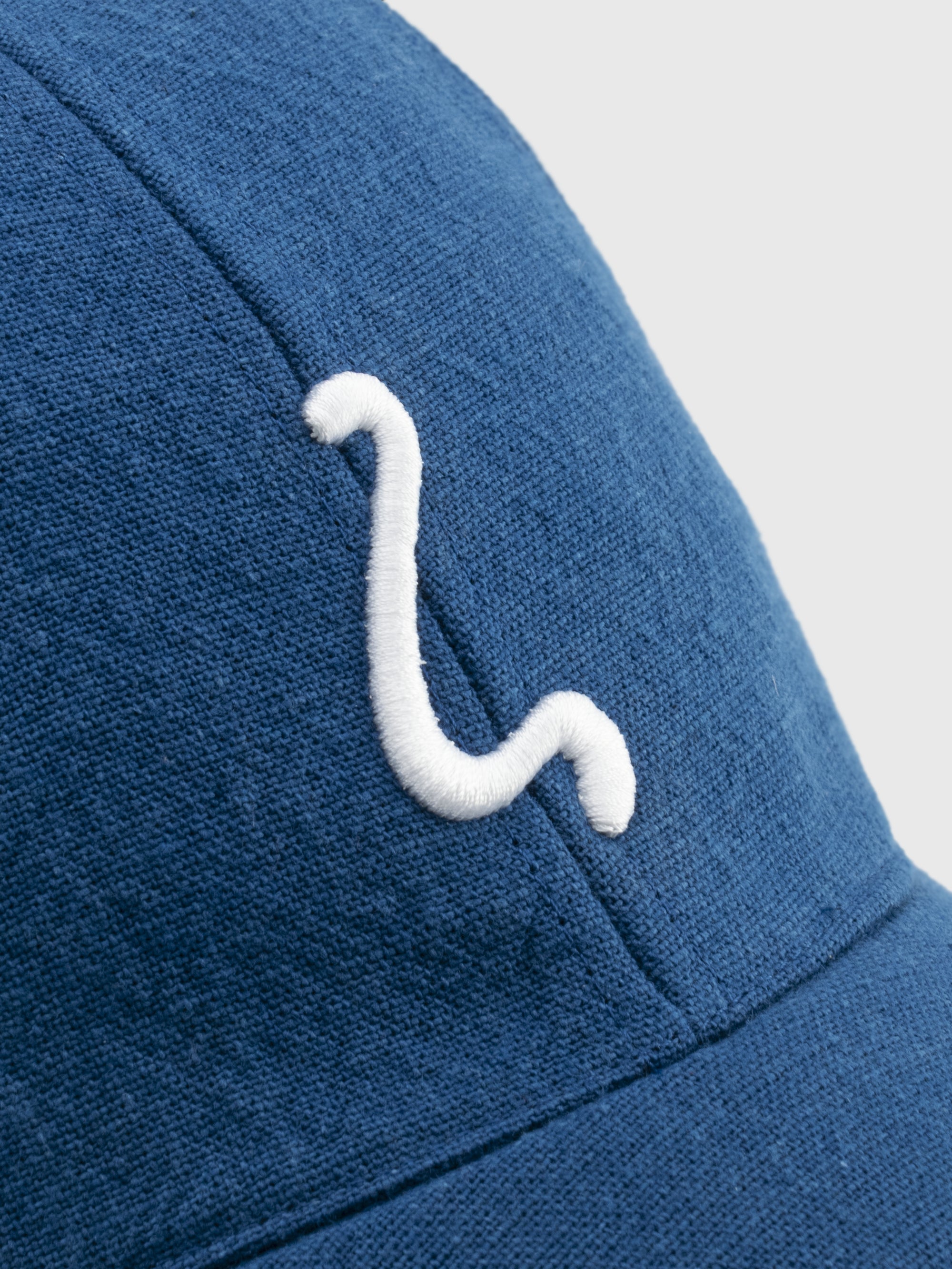 Blue cap with a white logo on a light gray background