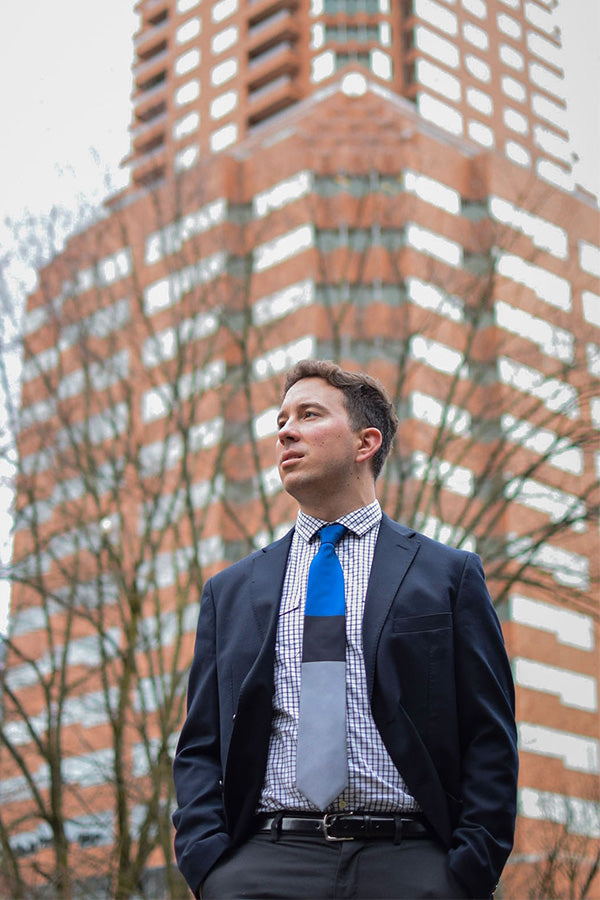 Lesovs Blue Black and Gray Tie in front of building